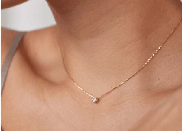 На зображенні жінка у якої на шиї золотє колье з фіанітом